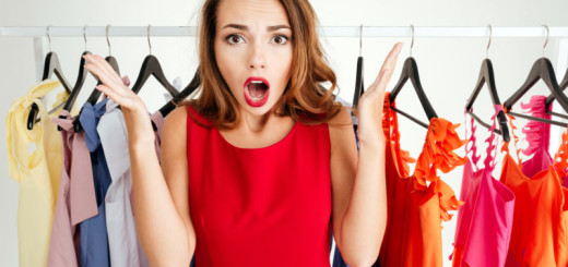 Confused lovely woman in red dress choosing what to wear